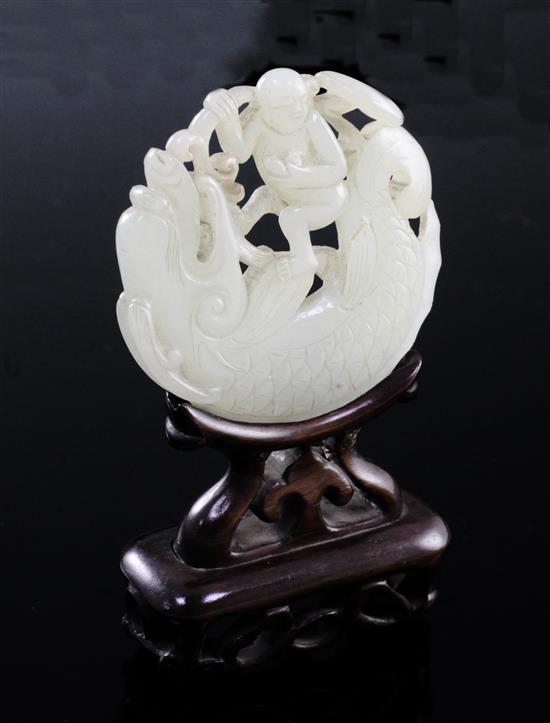 A Chinese pale celadon jade fish-dragon and boy disc, 18th century, diameter 6.1cm, rosewood stand